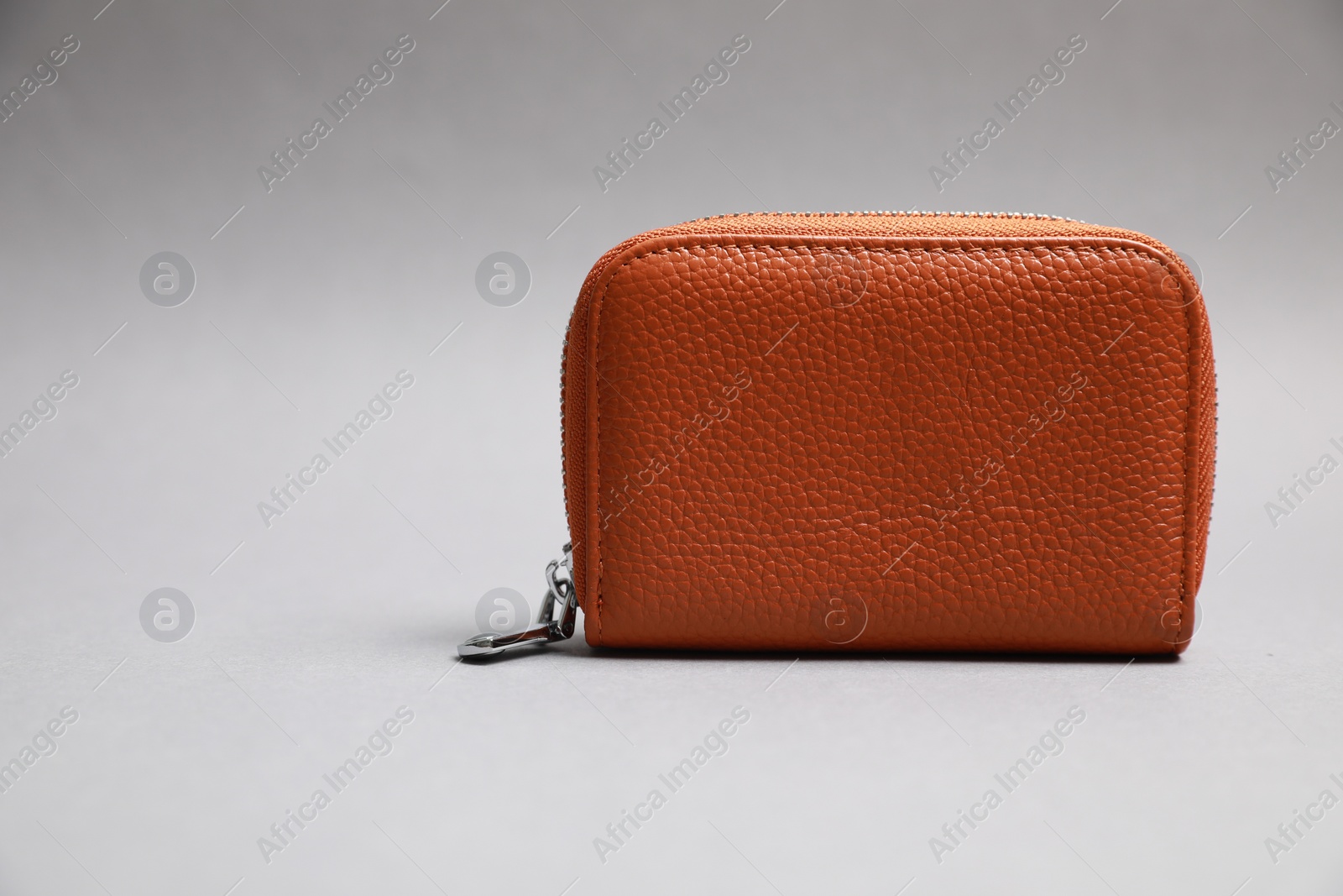 Photo of Stylish brown leather purse on light grey background. Space for text