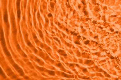 Image of Rippled surface of clear water on orange background