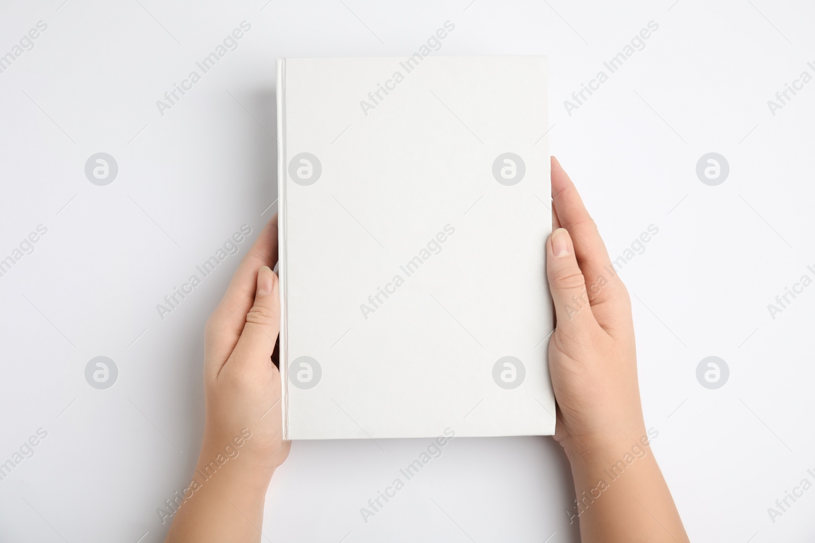 Photo of Woman holding book with blank cover on white background, top view