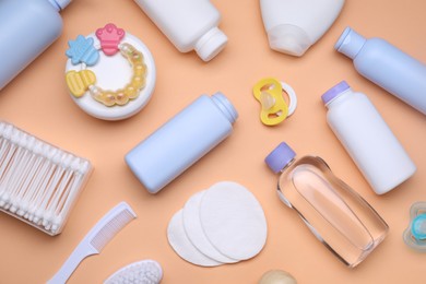 Photo of Flat lay composition with baby care products and accessories on pale orange background