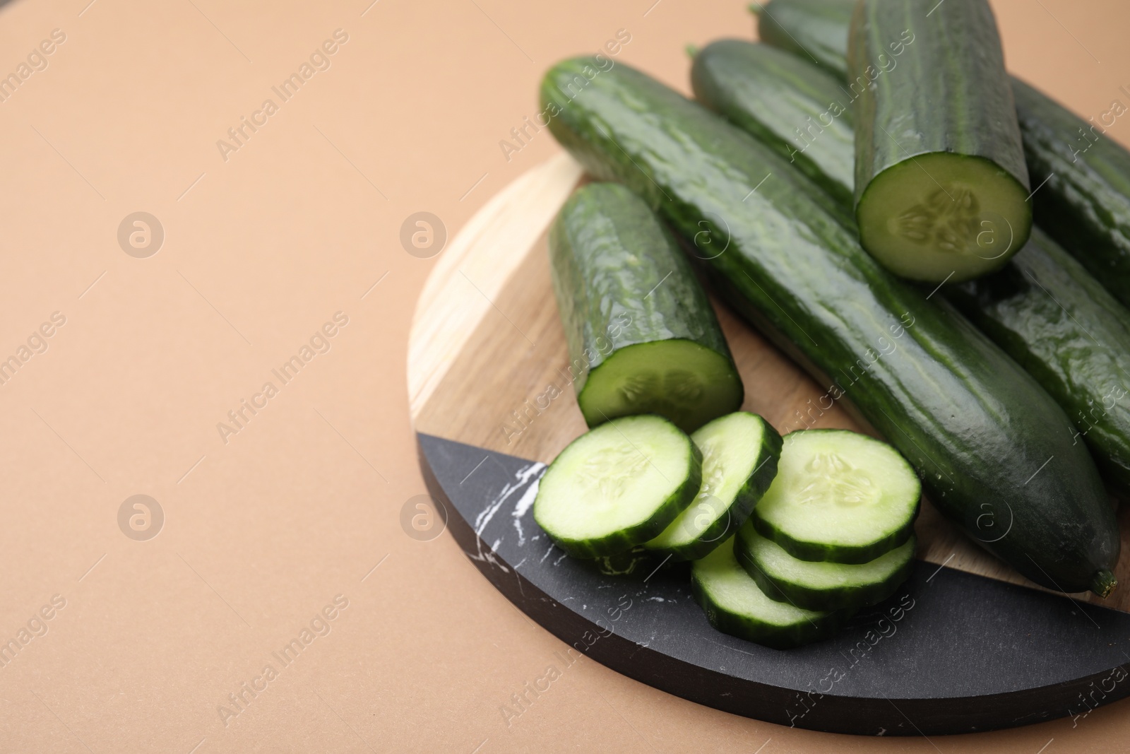 Photo of Fresh cucumbers on beige background, closeup. Space for text