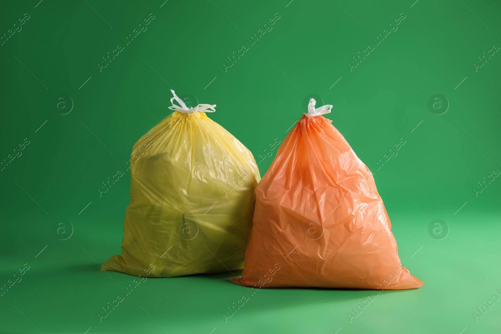 Photo of Trash bags full of garbage on green background