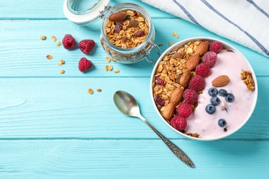 Photo of Tasty homemade granola served  on blue wooden table, flat lay. Healthy breakfast