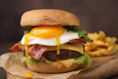 Photo of Delicious burger with fried egg served on table, closeup