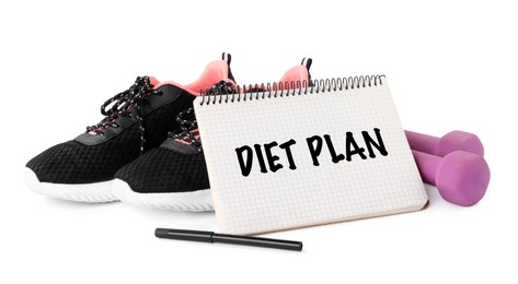Photo of Notebook with phrase Weight Loss Program, sneakers and dumbbells on white background