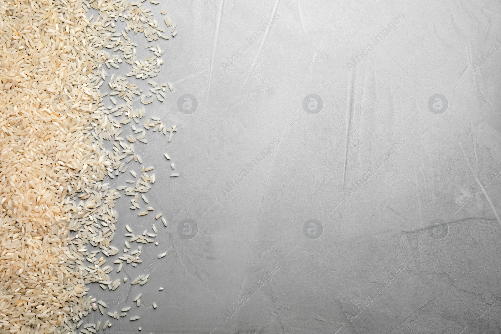 Photo of Rice on light grey table, top view. Space for text