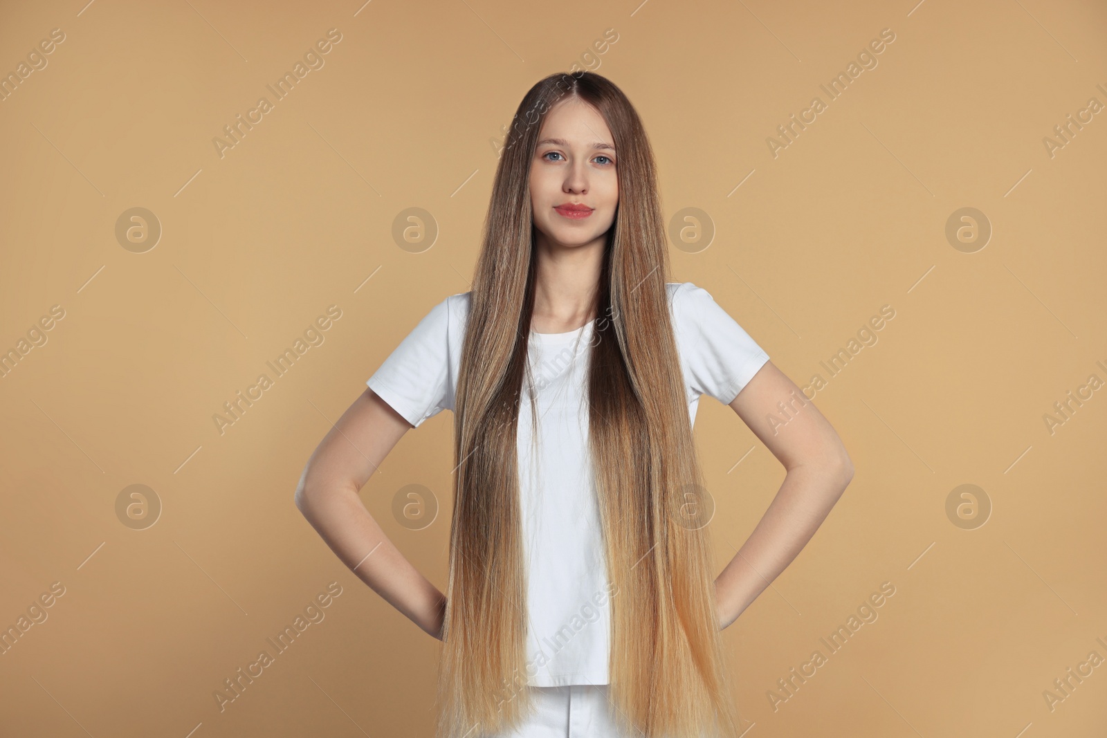 Photo of Teenage girl with strong healthy hair on beige background