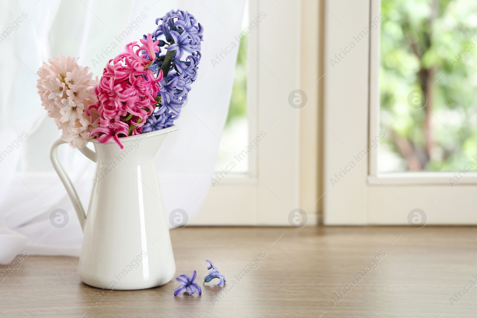 Photo of Beautiful fresh hyacinths on window sill indoors. Spring flowers