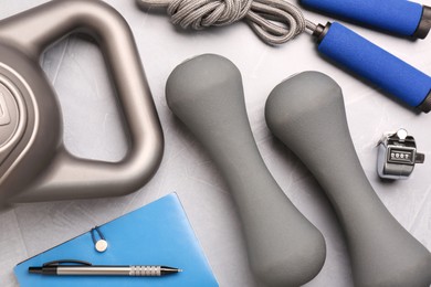 Photo of Flat lay composition with dumbbells on light grey table