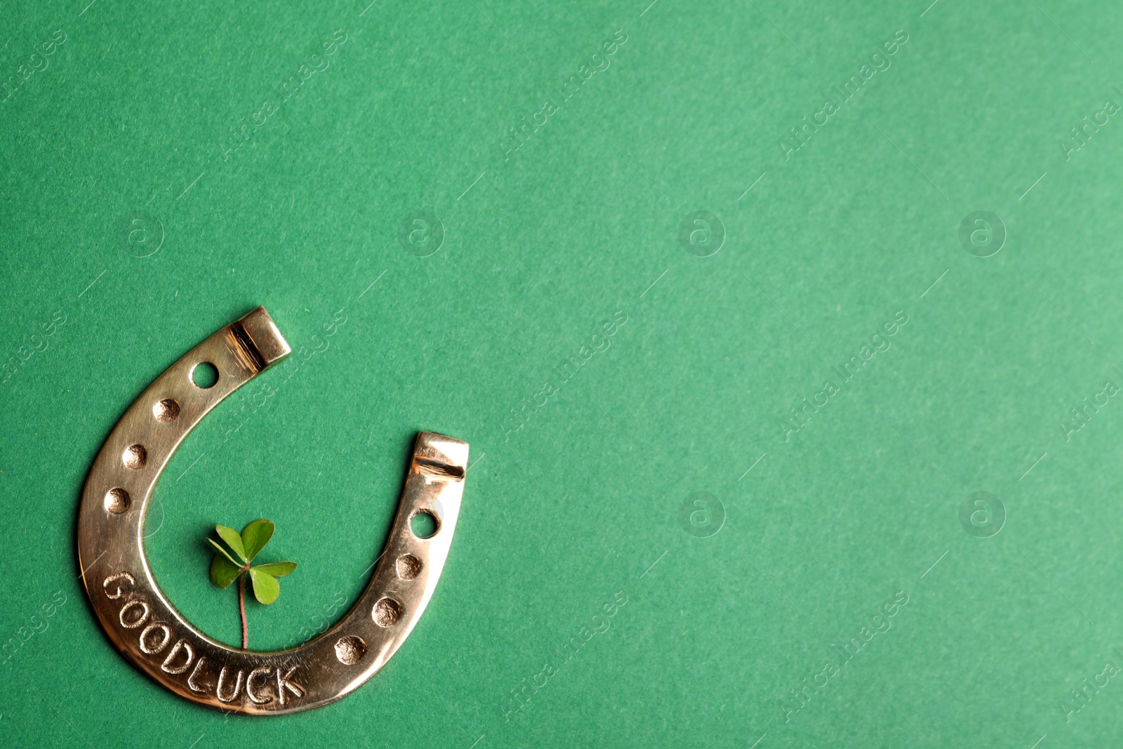 Photo of Flat lay composition with horseshoe on green background, space for text. St. Patrick's Day celebration