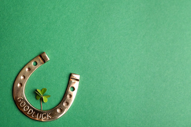 Photo of Flat lay composition with horseshoe on green background, space for text. St. Patrick's Day celebration