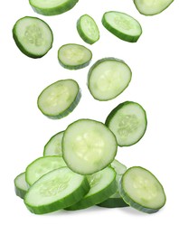 Slices of fresh green cucumbers falling on white background