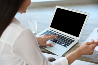 Woman using video chat on laptop in home office, closeup. Space for text