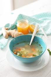 Bowl of fresh homemade soup to cure flu on wooden table