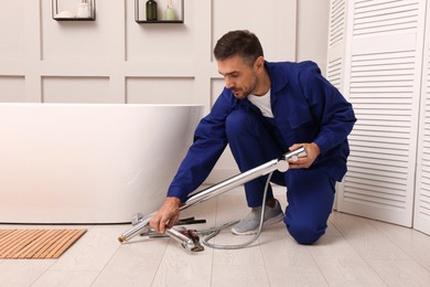 Professional plumber installing water tap in bathroom