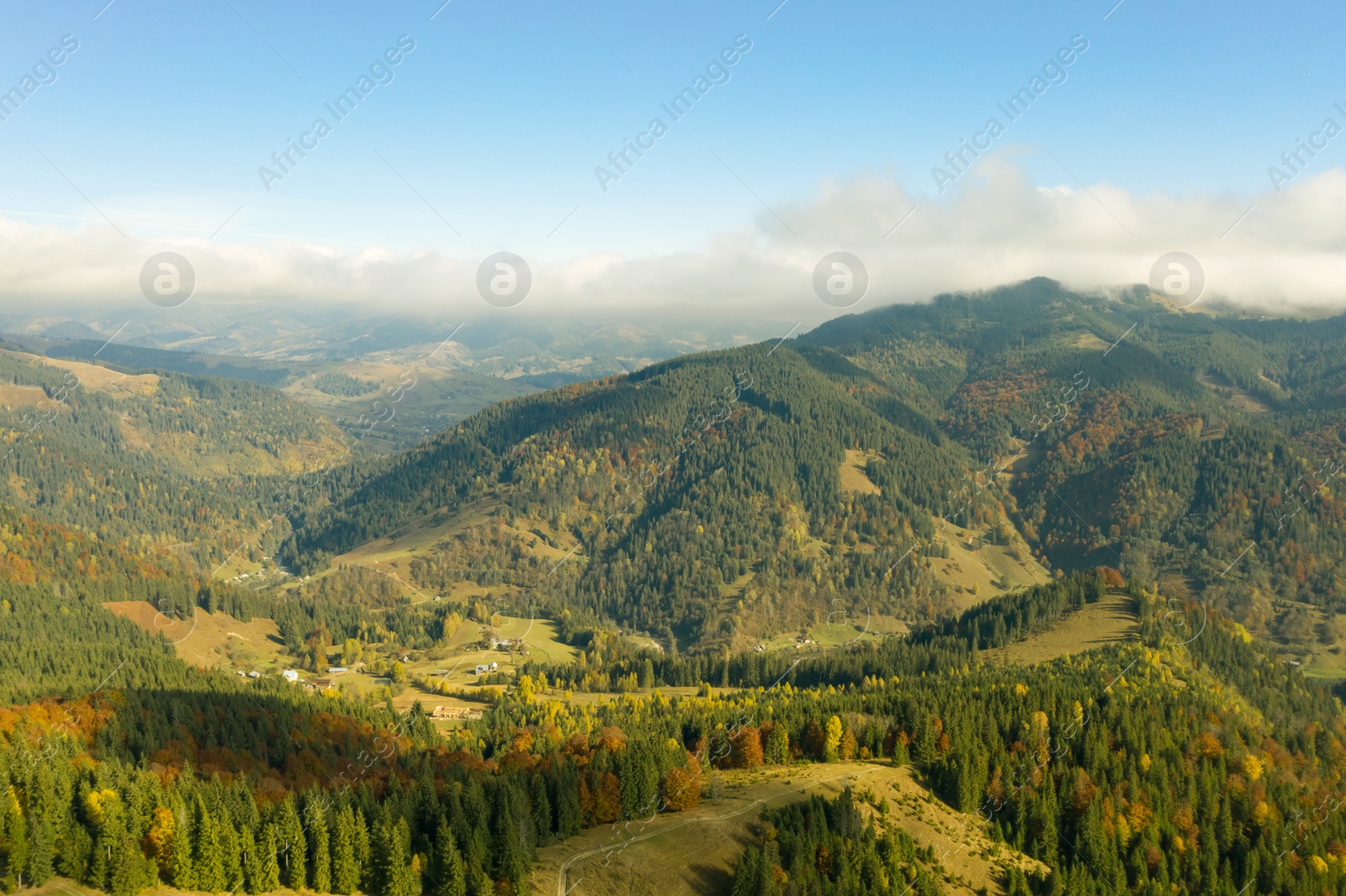 Image of Aerial view of beautiful mountain forest and village on autumn day