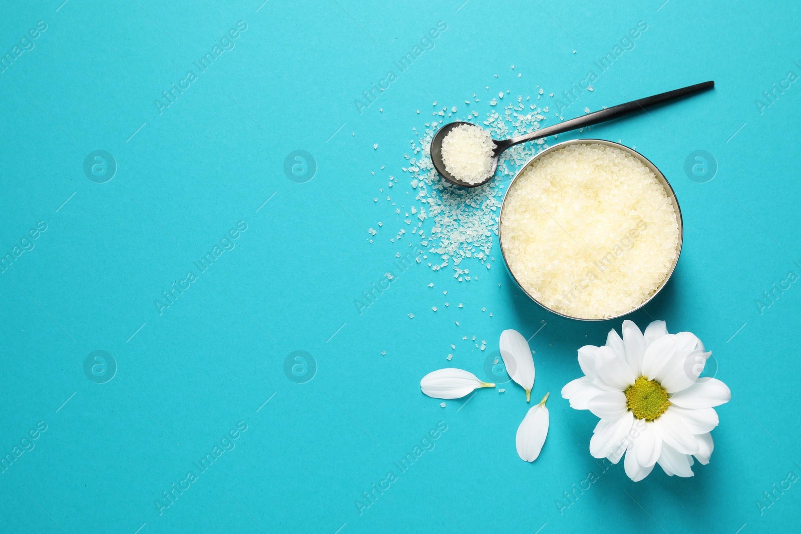 Photo of Natural sea salt, chamomile and petals on light blue background, flat lay. Space for text