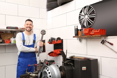 Mechanic near car disk lathe machine at tire service