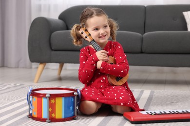 Little girl playing toy guitar at home