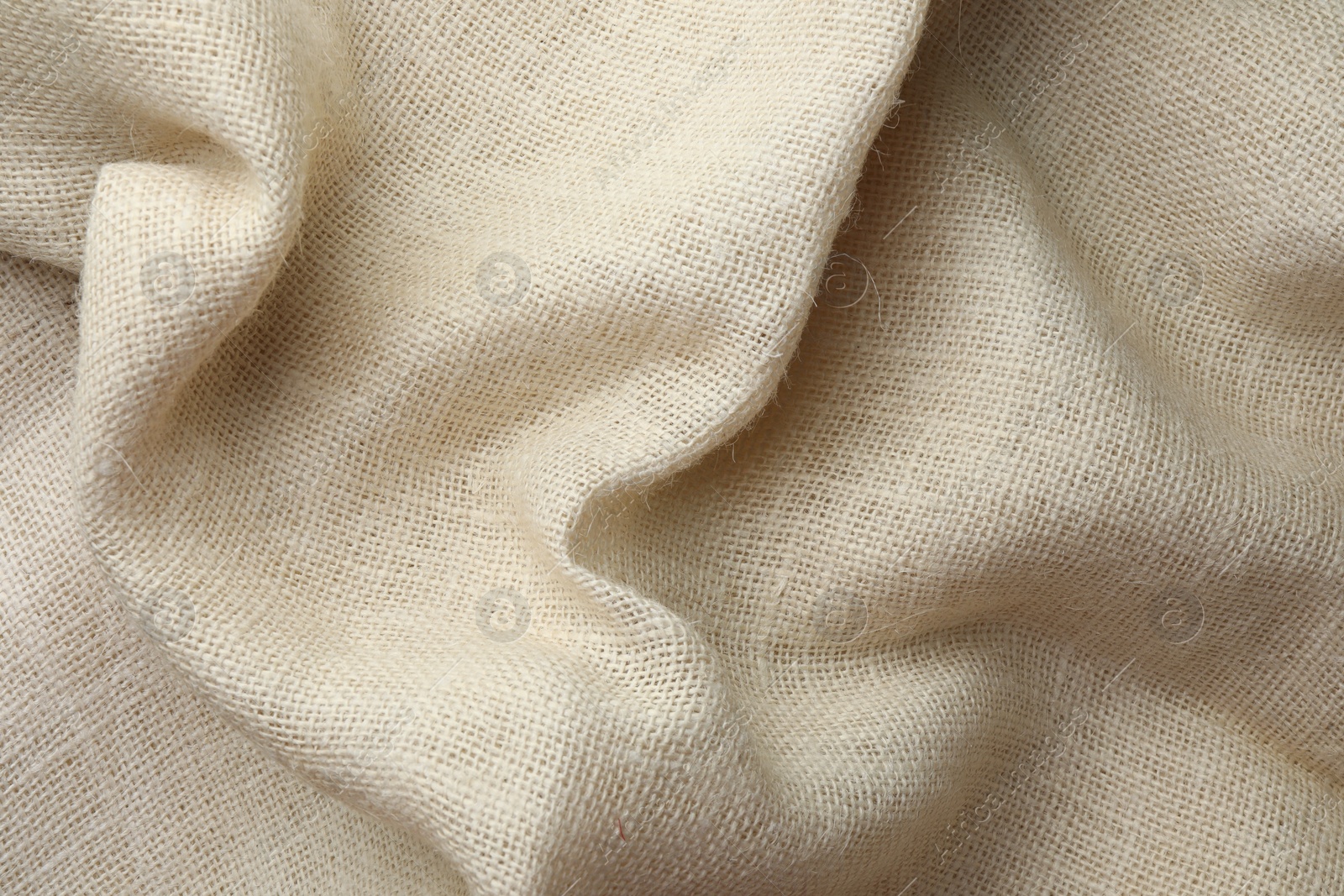 Photo of Texture of beige crumpled fabric as background, top view