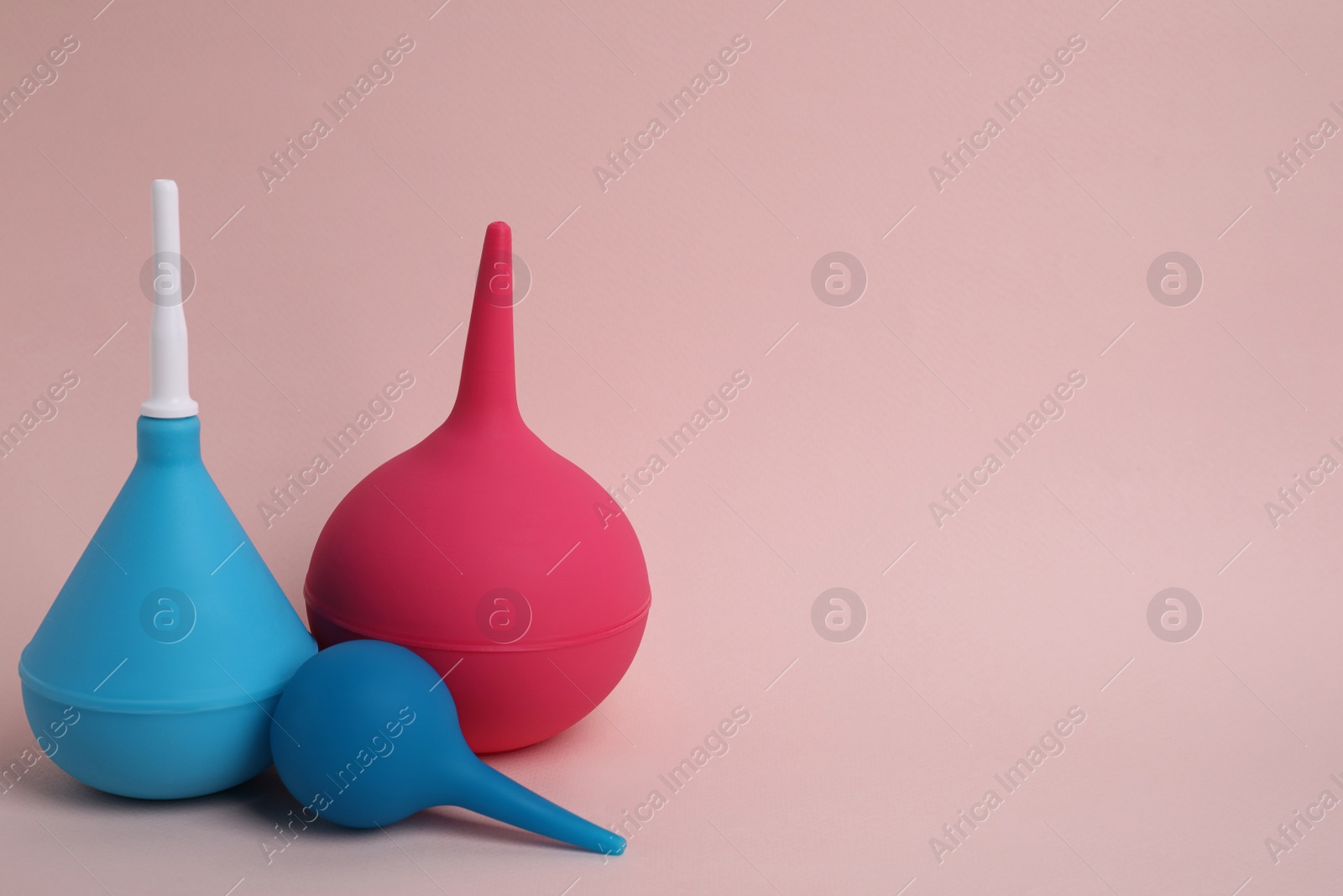 Photo of Different enemas on pink background, space for text. Medical treatment