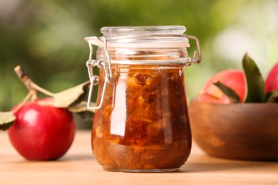 Photo of Delicious apple jam and fresh fruits on wooden table