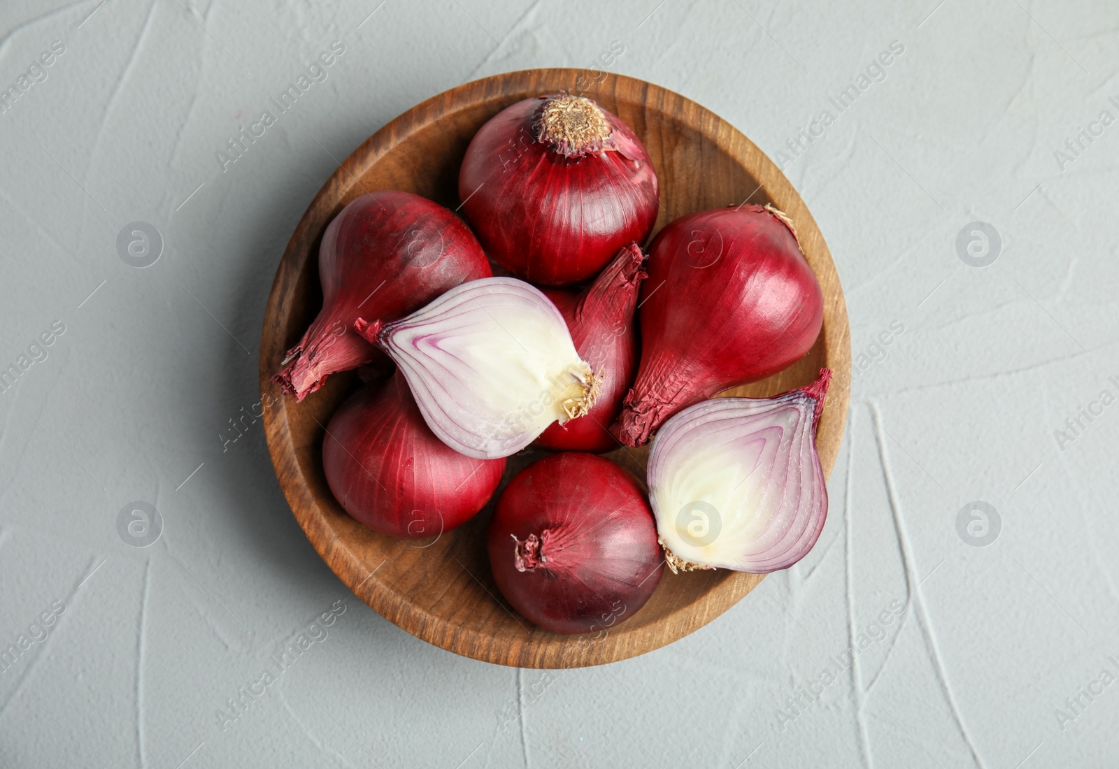 Photo of Plate with ripe red onions on table, top view