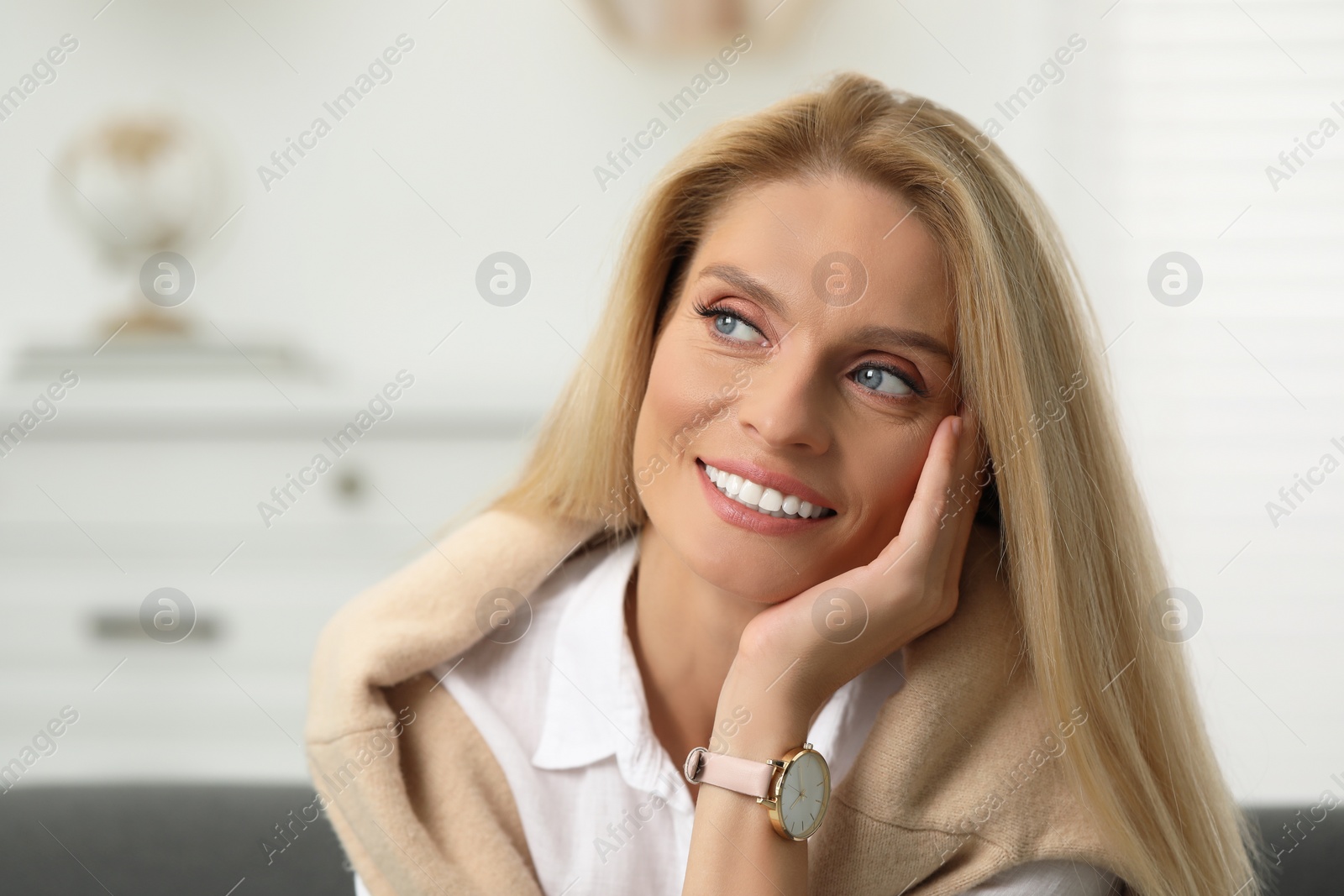 Photo of Portrait of smiling middle aged woman with blonde hair indoors