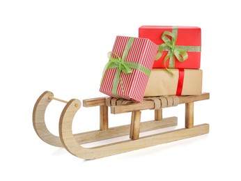 Photo of Wooden sleigh with Christmas gift boxes on white background