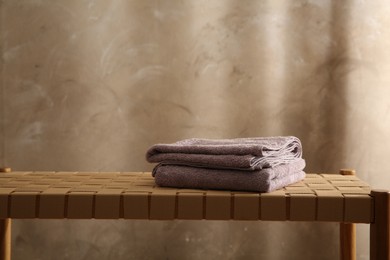 Soft terry towels on wicker bench indoors