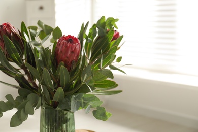 Vase with bouquet of beautiful Protea flowers indoors, closeup