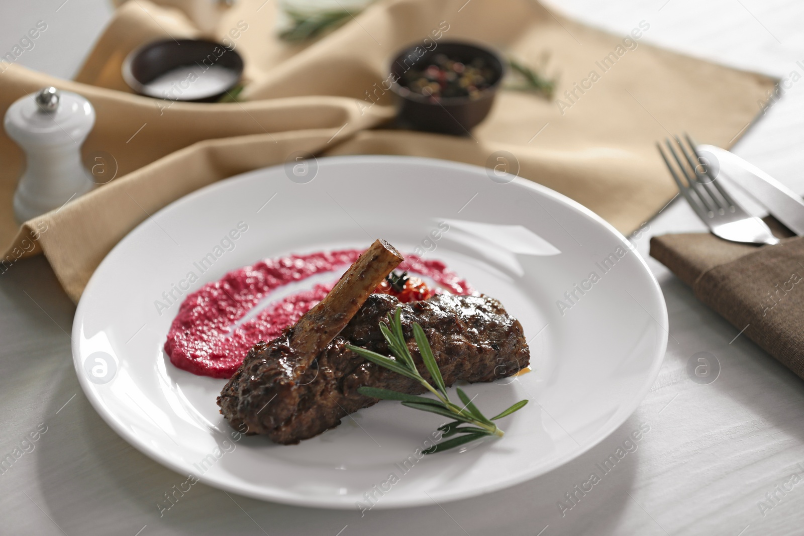 Photo of Delicious roasted rib served on white wooden table