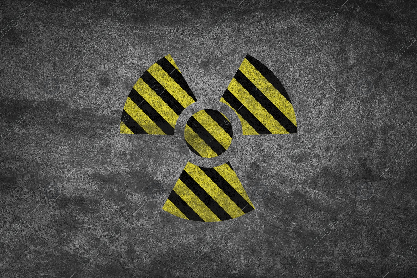 Image of Radioactive sign on grey stone wall. Hazard symbol