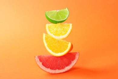 Photo of Cut fresh citrus fruits on orange background