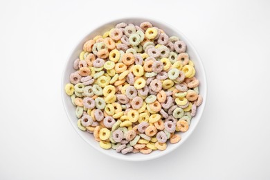 Tasty cereal rings in bowl on white table, top view