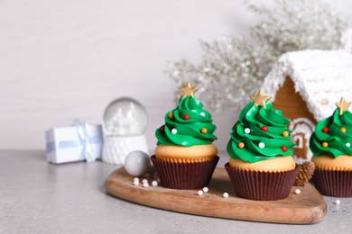 Christmas tree shaped cupcakes on light grey table