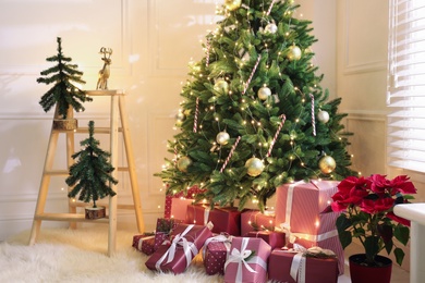 Many different gifts under Christmas tree indoors