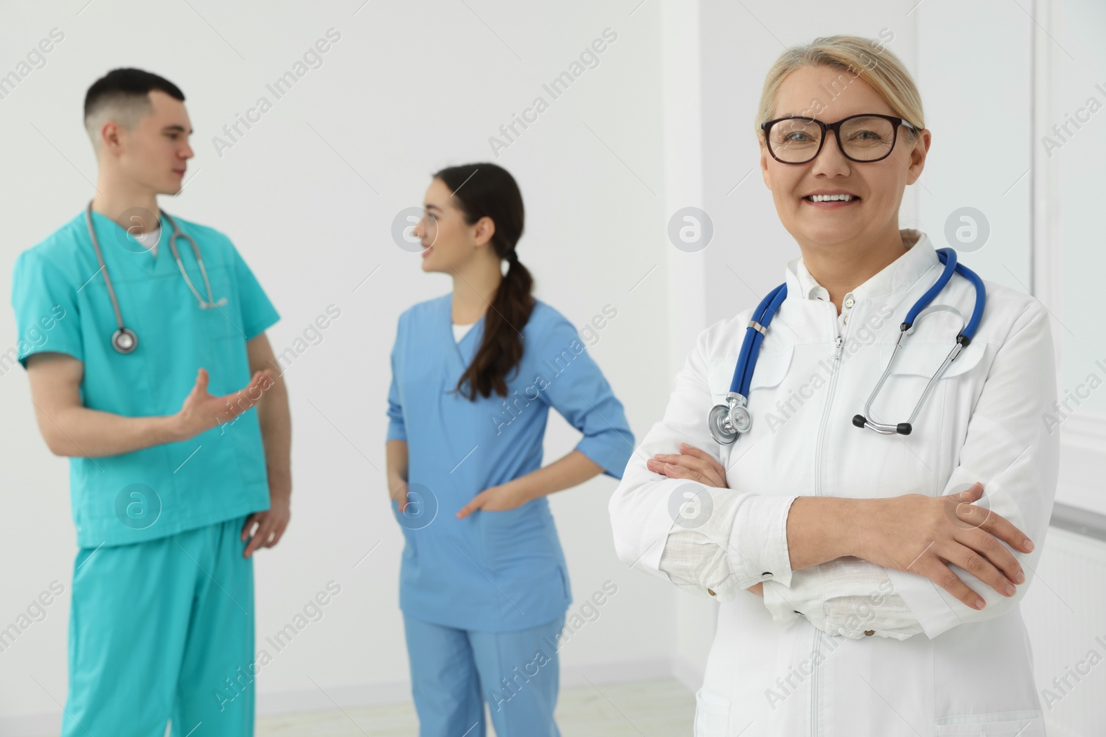 Photo of Portrait of doctor near colleagues in clinic