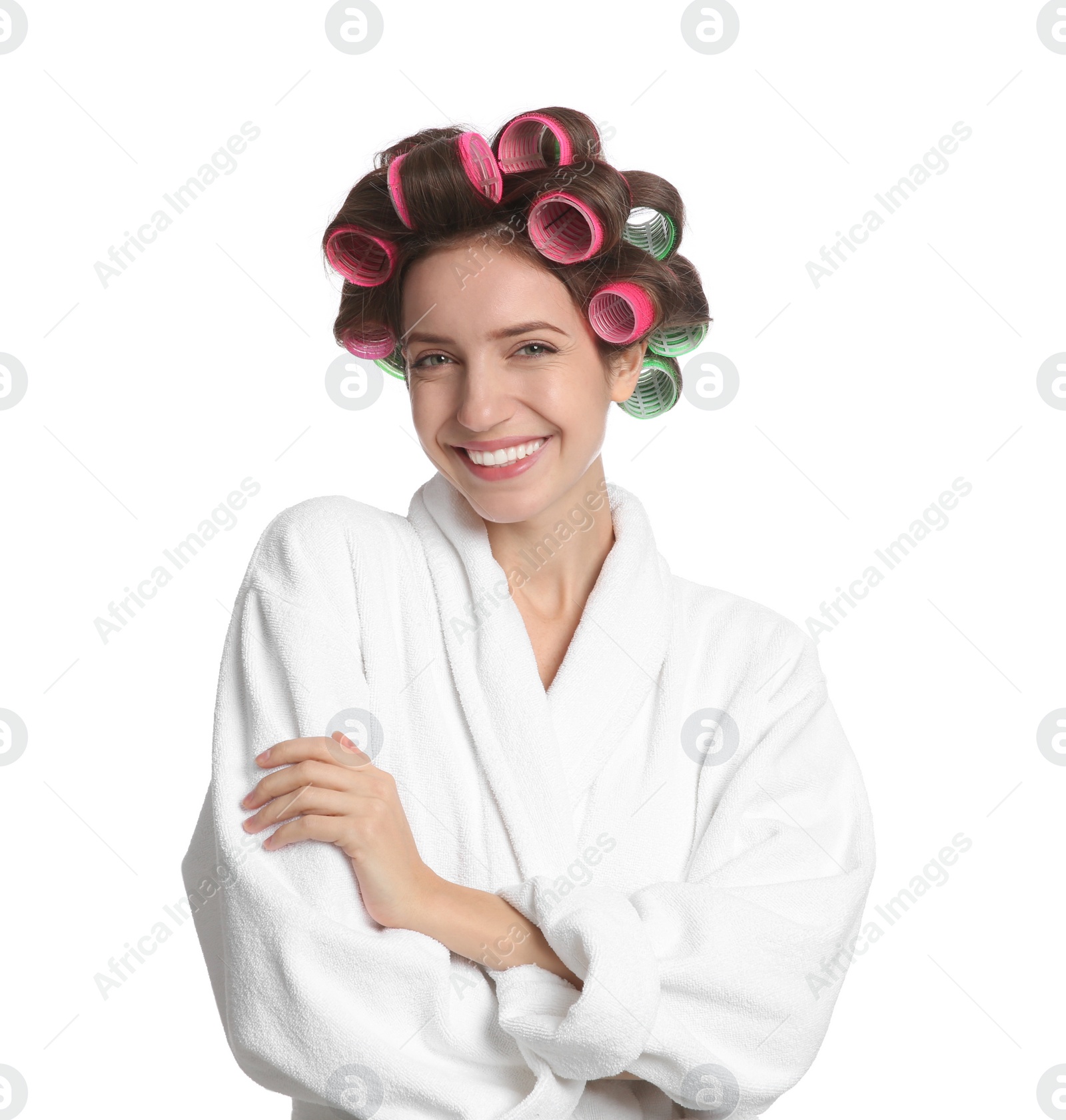 Photo of Beautiful young woman in bathrobe with hair curlers on white background