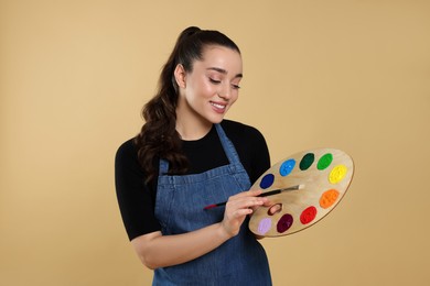 Woman with painting tools on beige background. Young artist