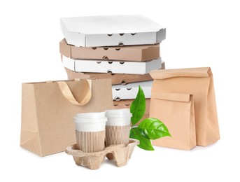 Different containers, coffee cups and green fresh leaves on white background