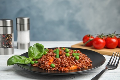 Photo of Plate of brown rice with vegetables on table