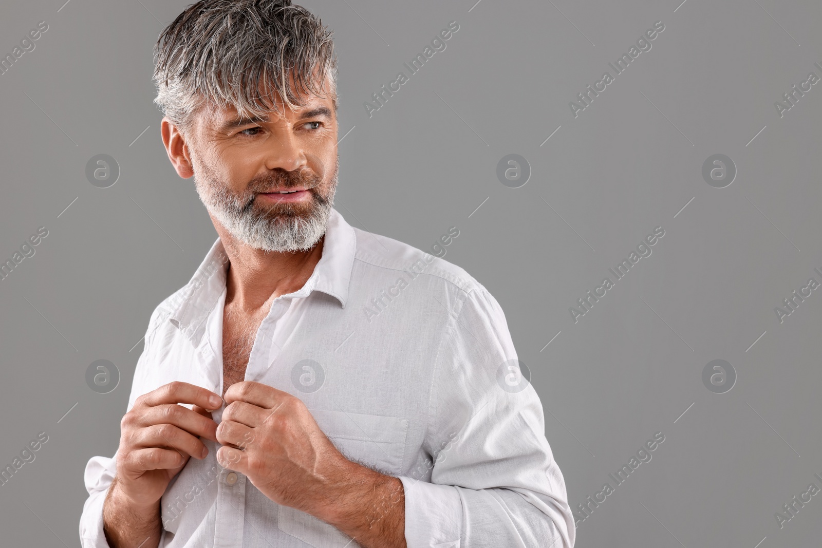 Photo of Portrait of confident man with beautiful hairstyle on light grey background. Space for text