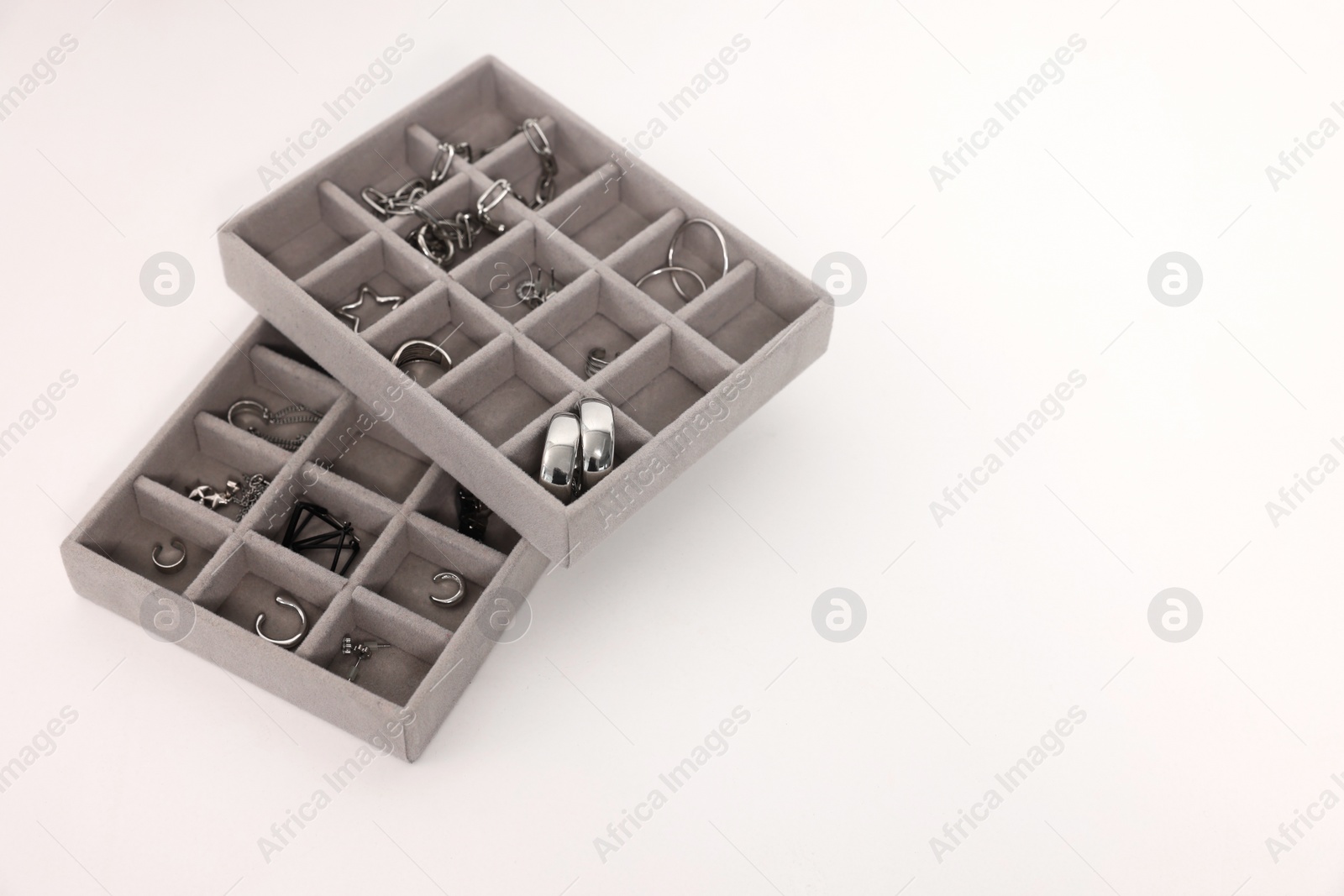 Photo of Jewelry boxes with many silver accessories on white table, above view. Space for text