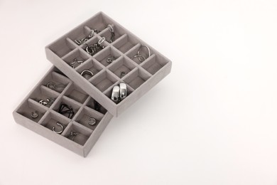 Photo of Jewelry boxes with many silver accessories on white table, above view. Space for text