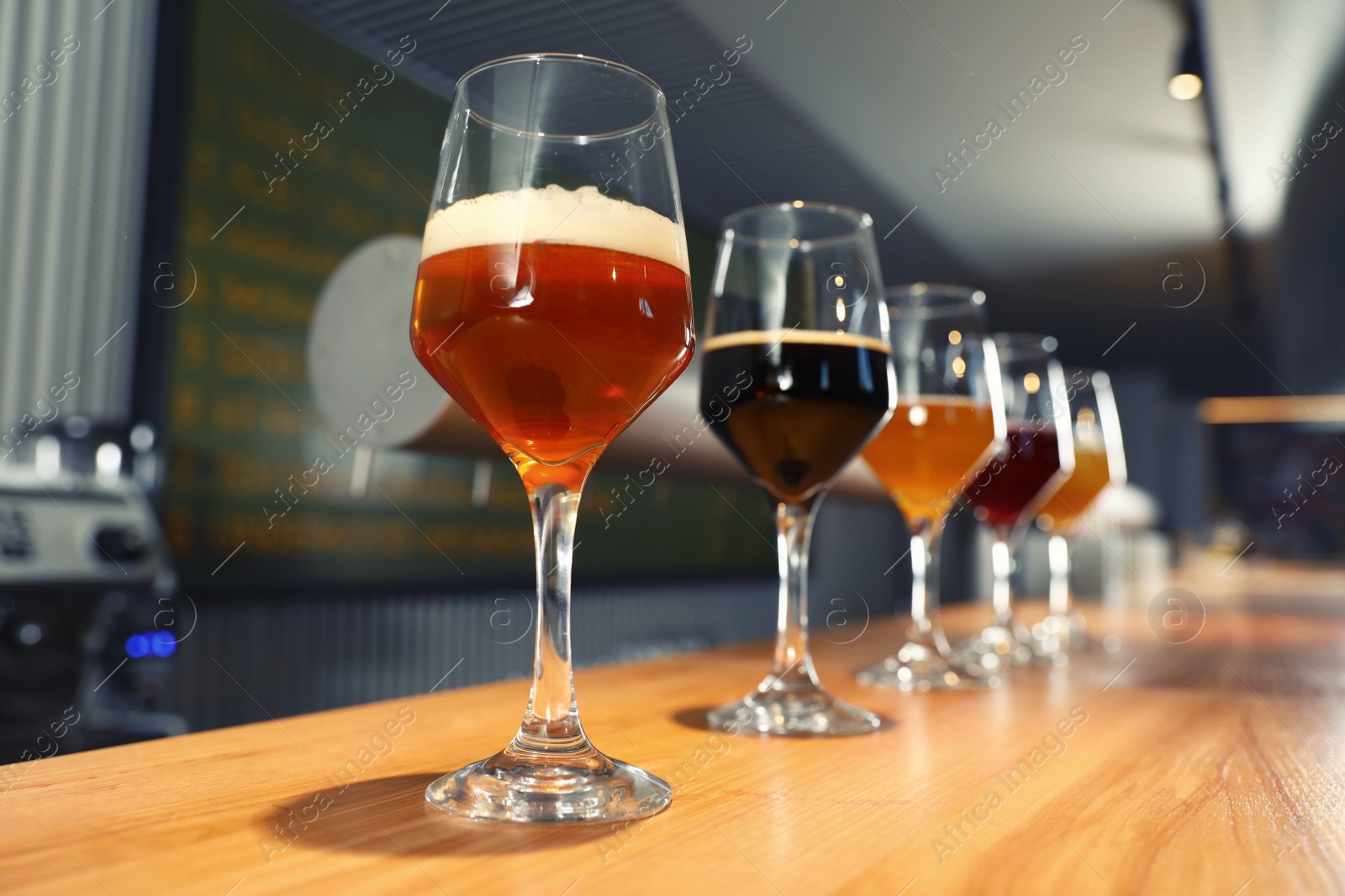 Photo of Different sorts of beer on wooden bar counter