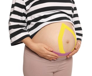 Pregnant woman with kinesio tapes on her belly against white background, closeup