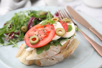 Photo of Tasty bruschetta with tomatoes, mozzarella and olives on plate, closeup