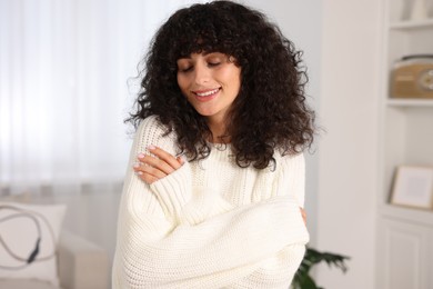 Photo of Happy young woman in stylish white sweater indoors