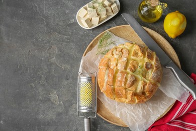 Photo of Freshly baked bread with tofu cheese served on grey table, flat lay. Space for text